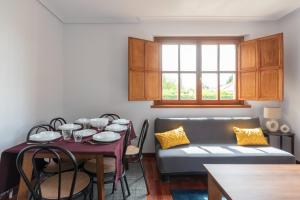 a living room with a table and a couch at Piso en Pedreña - 32001 in Pedreña