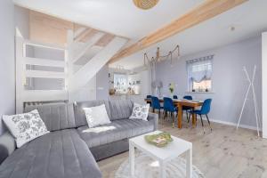 a living room with a couch and a table at Dom Wakacyjny Kropla Bałtyku w Darłówku z Ogrodem by Noclegi Renters in Darłowo
