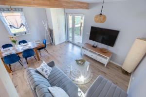 a living room with a couch and a tv at Dom Wakacyjny Kropla Bałtyku w Darłówku z Ogrodem by Noclegi Renters in Darłowo +17 photos