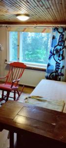 a bedroom with a chair and a bed and a window at Spacious Apartment for 8 with Sauna in Sievi
