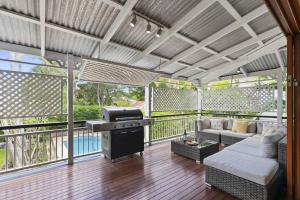 a screened in porch with a couch and a grill at Family Friendly, Pool, 9km to City by Custom Bnb Hosting in Brisbane