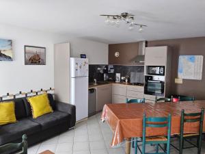 a kitchen and dining room with a table and a couch at Les Pres-Salés in Courtils