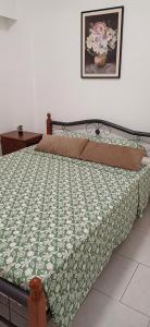 a bedroom with a bed with a green and white comforter at Makenzy Mermaid 2 Bedroom Apartment in Larnaca