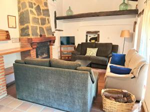 sala de estar con 2 sofás y chimenea en El Jiniebro Turismo Rural, en Valencia de Alcántara