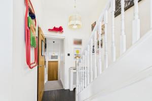 a hallway with white walls and a white stairway at Host & Stay - The Artists Pad in Saltburn-by-the-Sea