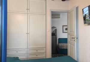 ein Schlafzimmer mit einem großen weißen Schrank und einem Bett in der Unterkunft Chrysa's cottage house in Karystos