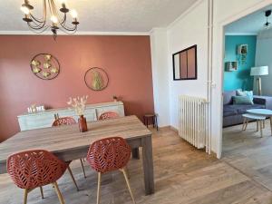 a dining room with a wooden table and chairs at Maison avec jardin & garage, 2 chambres, 6 personnes in Bonnétable