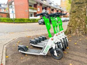 a green and white scooter parked next to a tree at ImmoStay City Apartments - Modern & WiFi in Bremen +50 photos