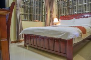 a bedroom with a large bed with a wooden headboard at Hong Kong Hotel in Dar es Salaam