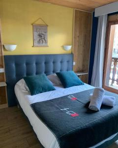 a bed with a blue headboard in a room at Hotel Le Concorde in Morzine