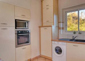 a kitchen with a washer and a sink and a microwave at Maison au charme champêtre - Monlaur-Bernet in Monlaur-Bernet +34 photos