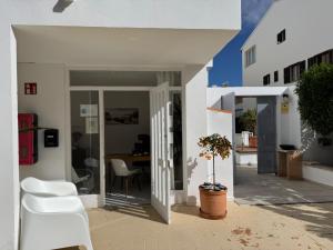 a white house with white chairs and a table at Orange Colom - Seaside Apartments in Portocolom