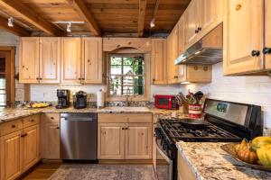 Una cocina con gabinetes de madera y electrodomésticos de acero inoxidable. en Belle Ridge, en Blue Ridge
