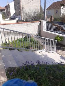 a white fence in a yard with purple flowers at appartement une chambre Champigny-sur-Marne in Nogent-sur-Marne