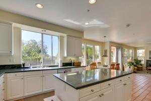 a kitchen with white cabinets and a large island at Coastal Haven in Encinitas