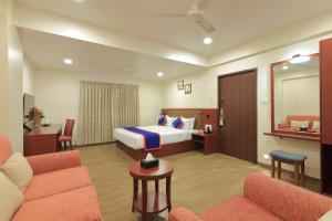 戈尔哈布尔Zip By Spree Hotels Kolhapur的一间带床和客厅的酒店房间