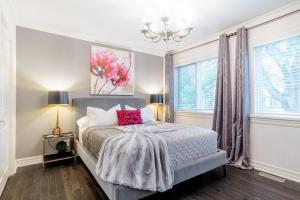 een slaapkamer met een bed en een kroonluchter bij Downtown Luxury Victorian Retreat in Toronto