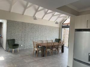 a dining room with a table and chairs and a refrigerator at The Gorge View at Highland Gate in Dullstroom
