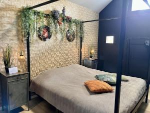 a bedroom with a four poster bed with plants on it at Gîte "Le Loft" in Chamblet