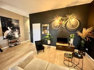 a living room with a couch and a bicycle on the wall at "Gîte Le Loft" - AIRCO in Chamblet