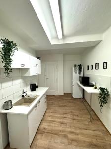 a kitchen with white cabinets and wooden floors at Nice rooms in City Center Kraków in Kraków