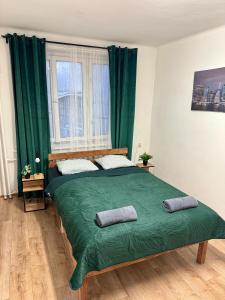 a bedroom with a large green bed with two pillows at Nice rooms in City Center Kraków in Kraków