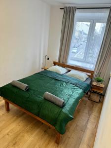 a bedroom with a large green bed with a window at Nice rooms in City Center Kraków in Kraków +4 photos
