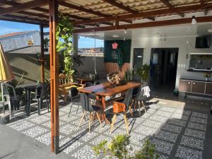 an outdoor patio with a wooden table and chairs at Jambu Hostel Belém in Belém