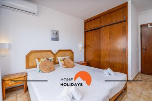 a bedroom with a bed with the words home holidays at #303 Atlantida Praia da Rocha by Home Holidays in Portimão +38 photos
