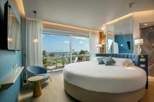 una camera da letto con un letto grande e una grande finestra di Ambasciatori Suite Hotel a Sottomarina