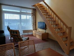 a living room with a staircase and a television at Eisvogel Classic 301 in Granzow