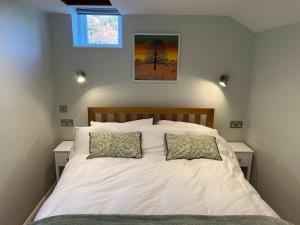 a bedroom with a white bed with two pillows at The Bakehouse in Castlemorton