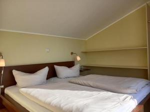a bed with white sheets and pillows in a room at Eisvogel Classic 301 in Granzow +19 photos