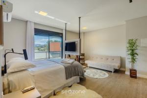 a bedroom with a large bed and a large window at Sua estadia perfeita em Urubici começa aqui! CZZ in Urubici