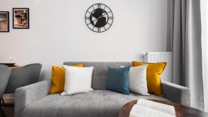 sala de estar con sofá gris y almohadas coloridas en Flatbook Apartamenty - Trimare Sztutowo z bilardem i parkingiem, en Sztutowo