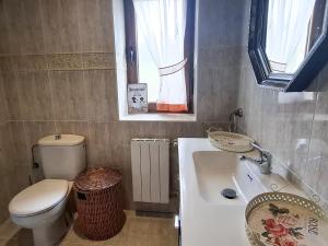a bathroom with a sink and a toilet and a window at Casa Entrepeñas 3000 in Villegar