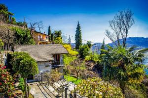 a house in a garden with a view of the mountains at Rustico La Vigna in Cannero Riviera