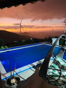 a swimming pool with a view of windmills at Margarida 02 in Monte das Gameleiras +6 photos