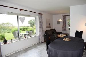ein Esszimmer mit einem Tisch und einem Fenster in der Unterkunft Haus Storjohann Dagebüll in Dagebüll