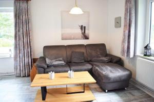 ein Wohnzimmer mit einem Ledersofa und einem Couchtisch in der Unterkunft Haus Storjohann Dagebüll in Dagebüll