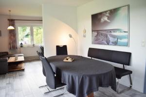 ein Wohnzimmer mit Tisch und Stühlen und einer Couch in der Unterkunft Haus Storjohann Dagebüll in Dagebüll