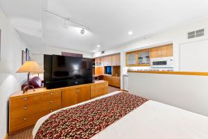 a bedroom with a bed and a flat screen tv at Palisades Tahoe Lodge Rentals Studio #115 in Olympic Valley