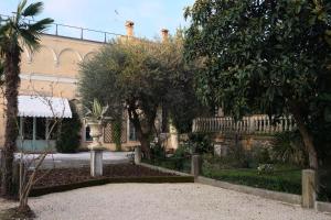 a garden with trees and a building in the background at Residenza Paulonia in Volta Mantovana