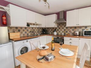 cocina con mesa de madera y copas de vino en Cantref House Top Floor, en Brecon