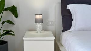 eine Lampe auf einem Nachttisch neben einem Bett in der Unterkunft Sciara Marina, Fiumefreddo di Sicilia, NUOVA STRUTTURA in Fiumefreddo di Sicilia