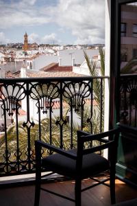 a chair on a balcony with a view of a city at Hotel Estepona Plaza in Estepona