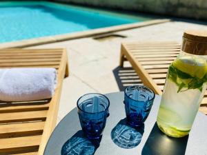 un tavolo con due bicchieri blu e una bottiglia di Gîte Eucalyptus L'Ecrin de Verdure piscine Chinon a Ligré
