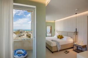 una camera da letto con un letto e vista sull'oceano di Ambasciatori Suite Hotel a Sottomarina