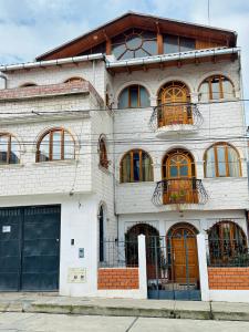 a white brick building with a lot of windows at Rajutuna Inn in Huaraz