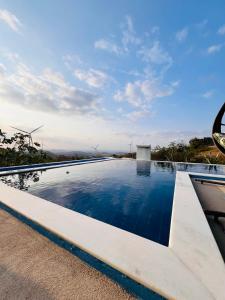 einem Pool mit Windmühlen im Hintergrund in der Unterkunft Margarida 04 in Monte das Gameleiras